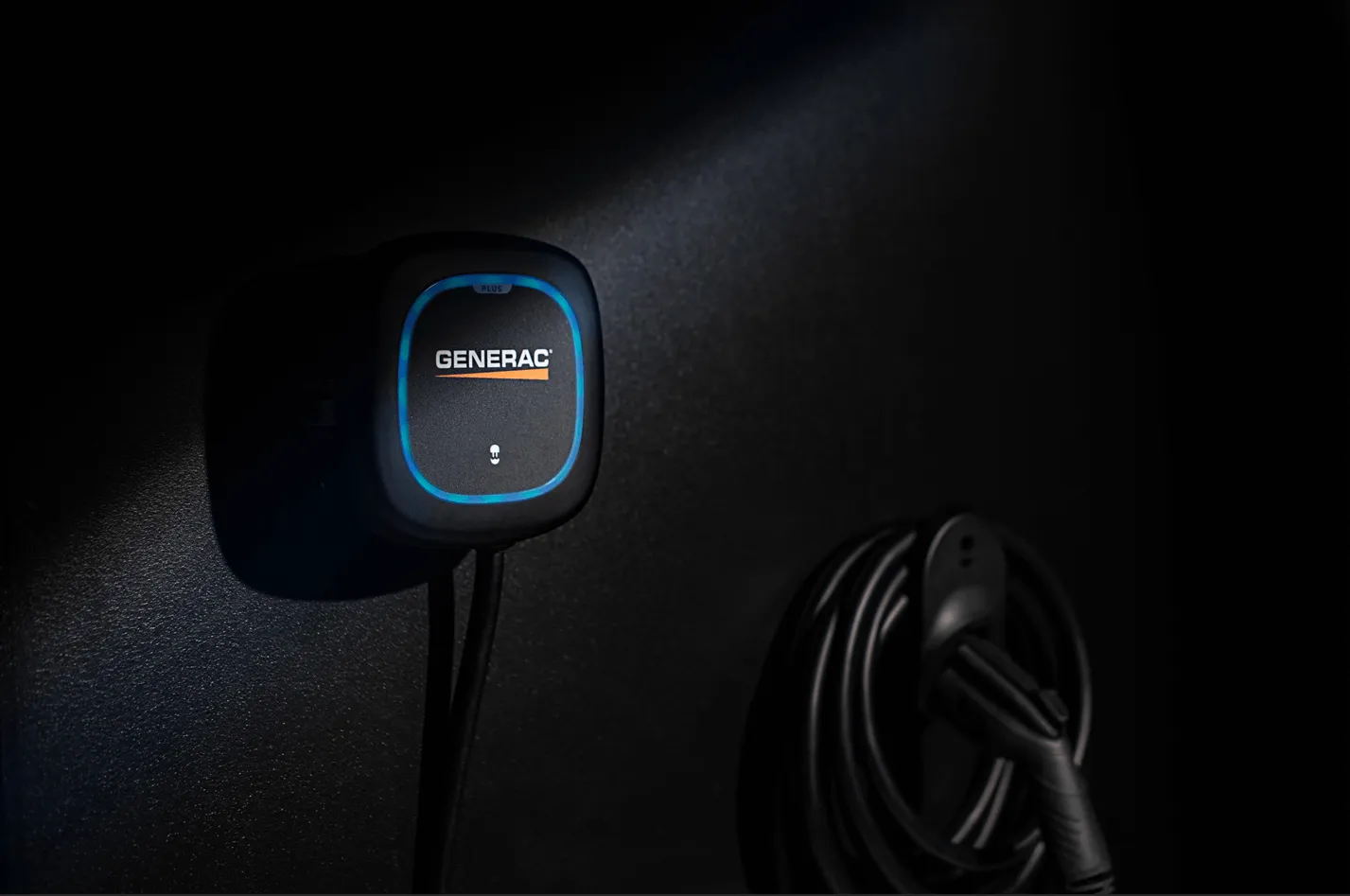 Person charging an electric vehicle with a Generac Level 2 charger